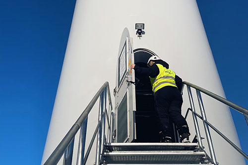 A woman opening a door to a wind turbine